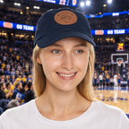 Woman wearing a navy blue cap with a logo of My Little Fe and a Dragonfly Stick at a baslketball stadium