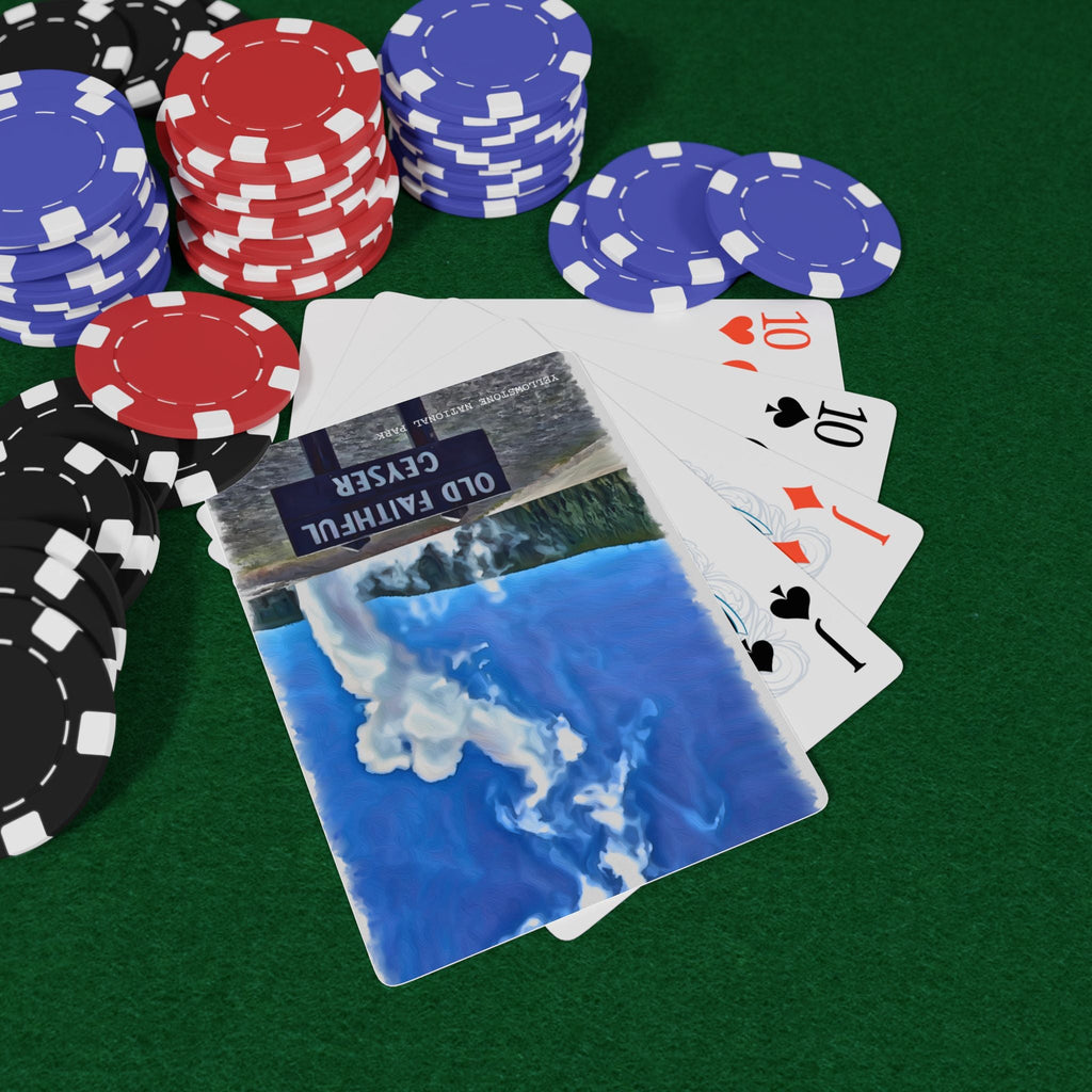 Poker chips and playing cards on a green felt surface with Yellowstone Old Faithful Geyser design