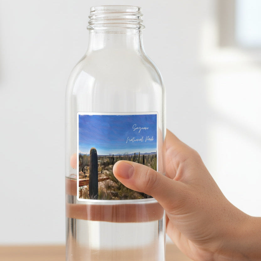 Saguaro National Park with cacti and blue sky on a water bottle with a hand holding it