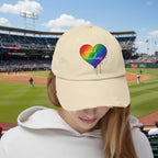 Beige cap with rainbow heart design and 'spread kindness' text at a baseball game