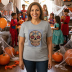 A woman wearing a light gray heather crewneck t-shirt featuring a colorful sugar skull graphic with a dragonfly on the chest hosting a kids halloween party