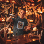 Bartender wearing dark gray t-shirt with Sugar Skull and Dragonfly design at a bar serving drinks with halloween decor