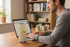 Tumbler with sunburst design and text on a home office desk with a man working on his laptop