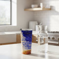 Tumbler with a blue and white abstract design on kitchen counter with a water carafe next to it.  From original painting by Bay Area Artist Marife Rosales of MyLittleFe