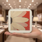 Hand holding a compact mirror with floral design in a store setting