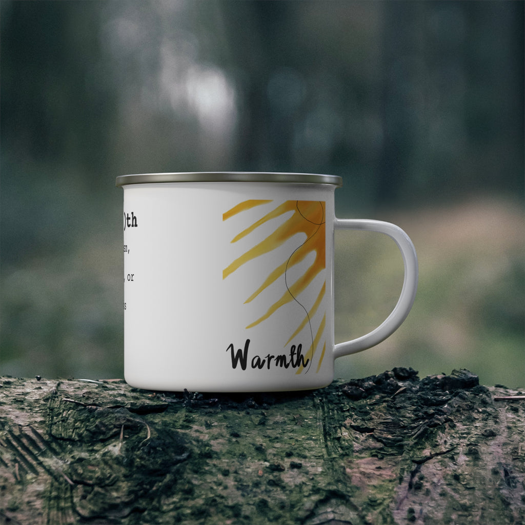 Mug with 'Warmth' text and sun design on a tree stump in a forest setting