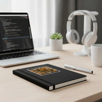 Spider on a keyboard with text 'Web Developer at work' on a black notebook on stop of a work desk with pen, laptop, headset, succulent plant and coffee mug
