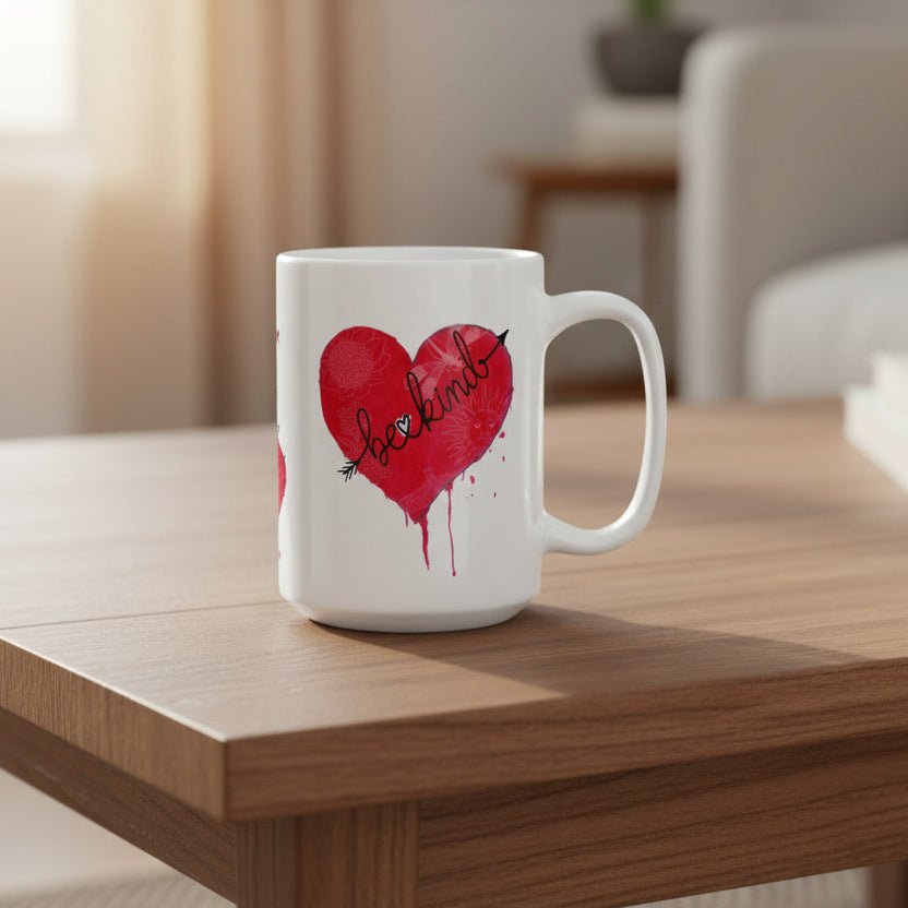 White mug with a red heart design and the word 'be kind' on a coffee table