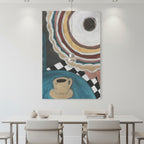 An abstract canvas wall art print featuring concentric circles, a coffee cup motif, and checkered patterns, displayed in a modern dining room setting above a white table and chairs.