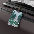 Luggage tag with forest design attached to a suitcase