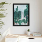 Framed artwork of a trees at Yosemite with waterfall scene on a wall above a desk with a plant and books.