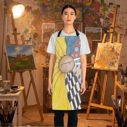 A woman modeling an apron with a colorful zentangle and sunflower half print, worn over a white t-shirt in an art studo