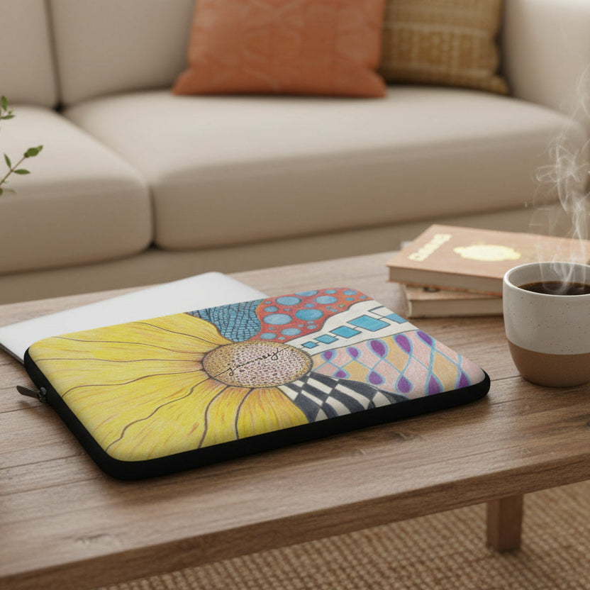 Laptop sleeve with a zentangle sunflower design on a coffee table