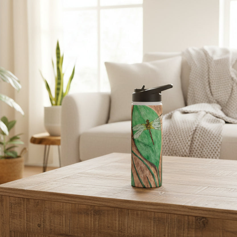 Tumbler with a dragonfly on a leaf design on a coffee table in a living room