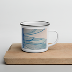 White enamel mug with blue dragonfly wings design on a wooden surface