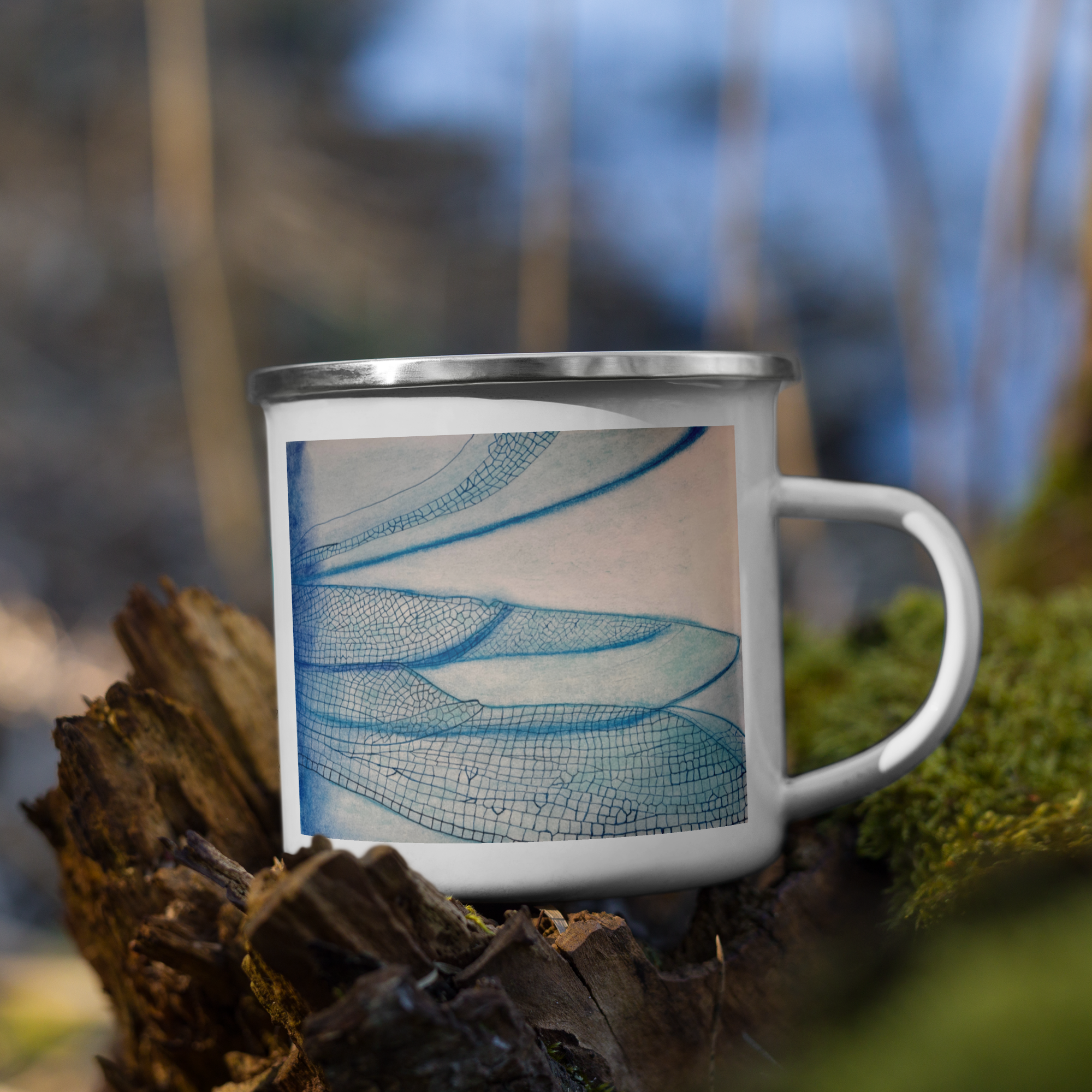 White mug with blue dragonfly wings design on a natural background