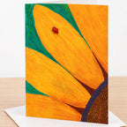 Close-up of a sunflower with a ladybug on an orange petal on a greeting card